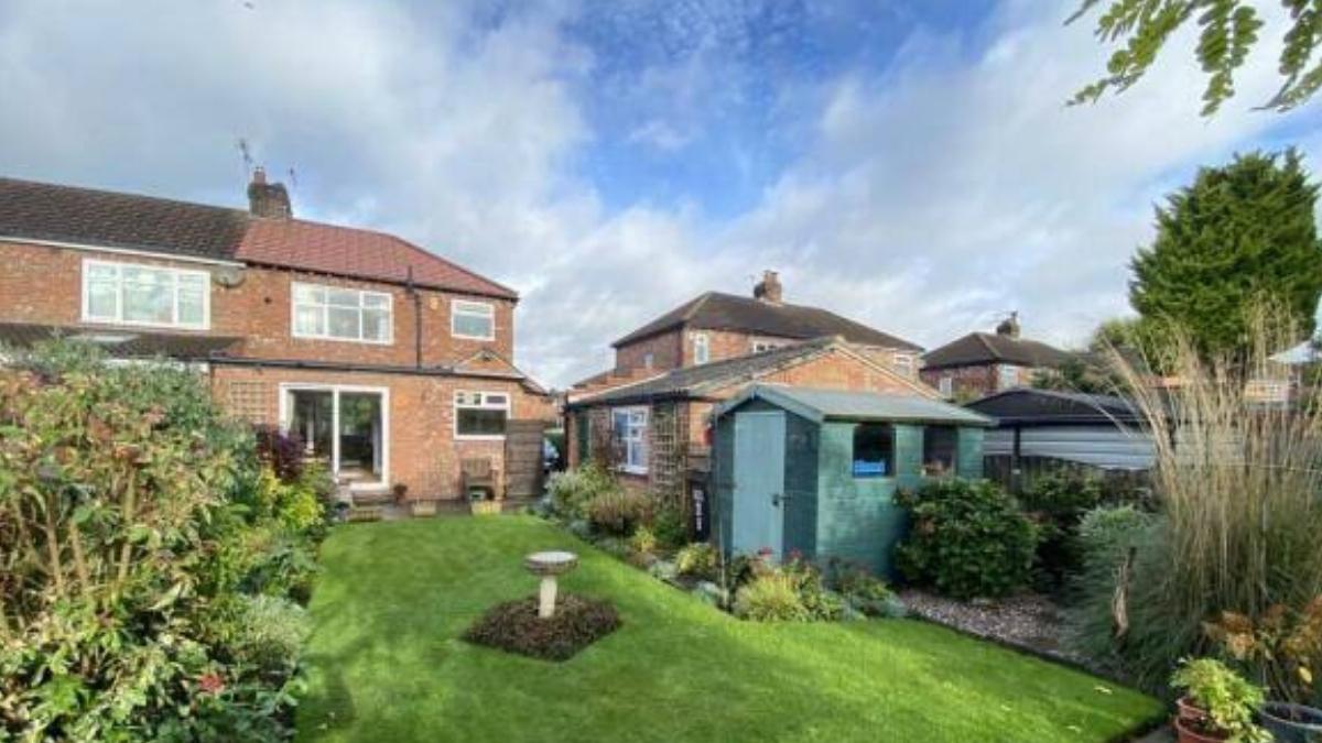 Wilmslow home extension with new pitched roof and Velux windows, viewed from the garden, showcasing a spacious and modern open-plan transformation.