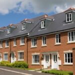 Front view of a modern parade of newly built semi-detached houses, featuring contemporary design and uniform facades.