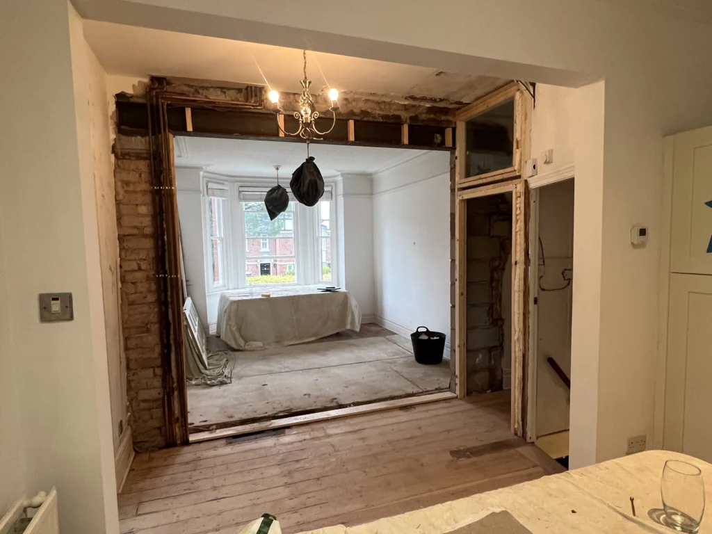 Internal load-bearing wall removed between living room and dining room in Sale, Trafford, with RSJ installed and temporary supports visible during structural works.